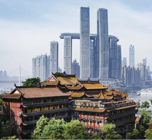 The image shows the traditional-style roof architecture of the Luohan Temple (Arhat Temple) in the foreground, with the ultra-modern Raffles City Chongqing skyscrapers rising in the background.